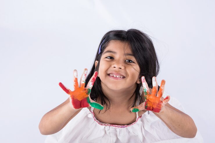 happy-holi-greeting-cute-little-indian-girl-with-colourful-hands-isolated-white-background_466689-10973